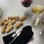 algumas rolhas de vinhos especiais com taças de vinho para provar e um saca rolhas de sommelier presente no cenário para ilustrar profissionalismo e bons vinhos a provar na península de Setúbal em Portugal